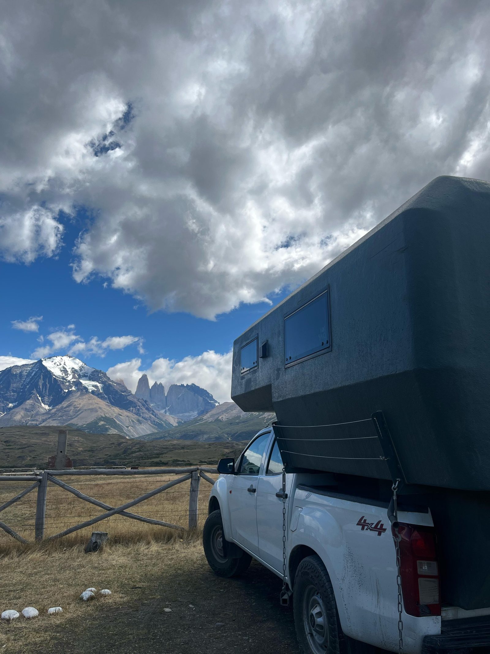 Camper truck 4x4 frente a montañas nevadas con cielo cubierto en la Patagonia
