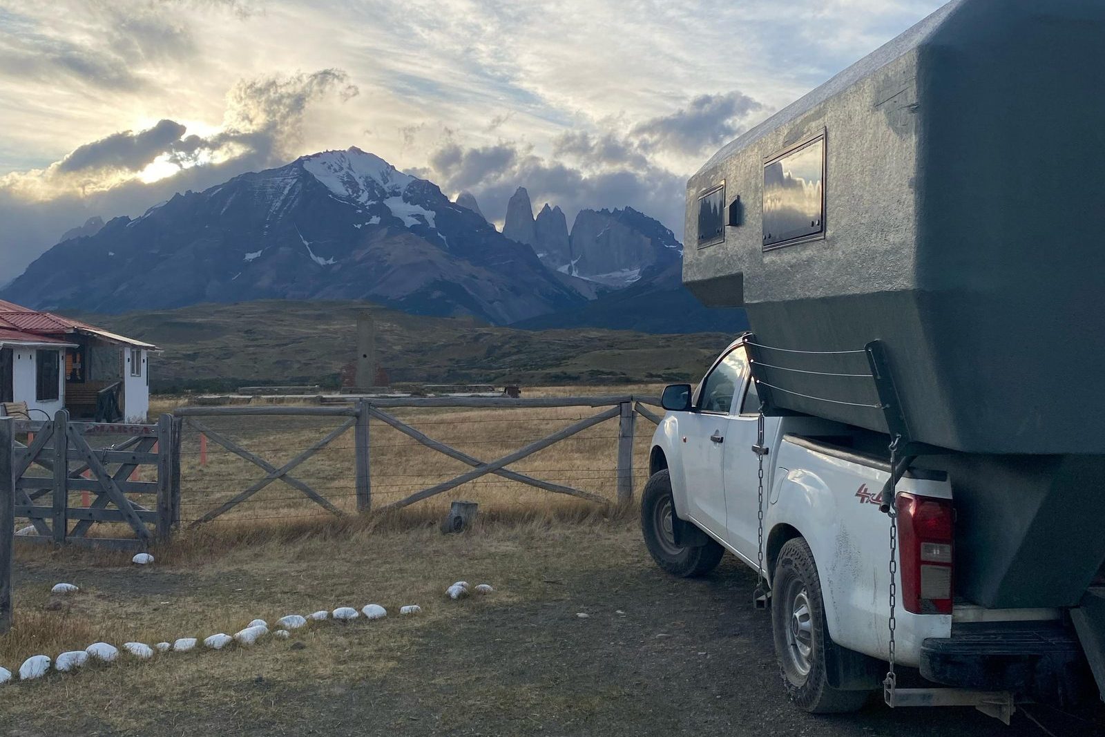 4x4 camper truck parked at dawn with the Paine massif behind