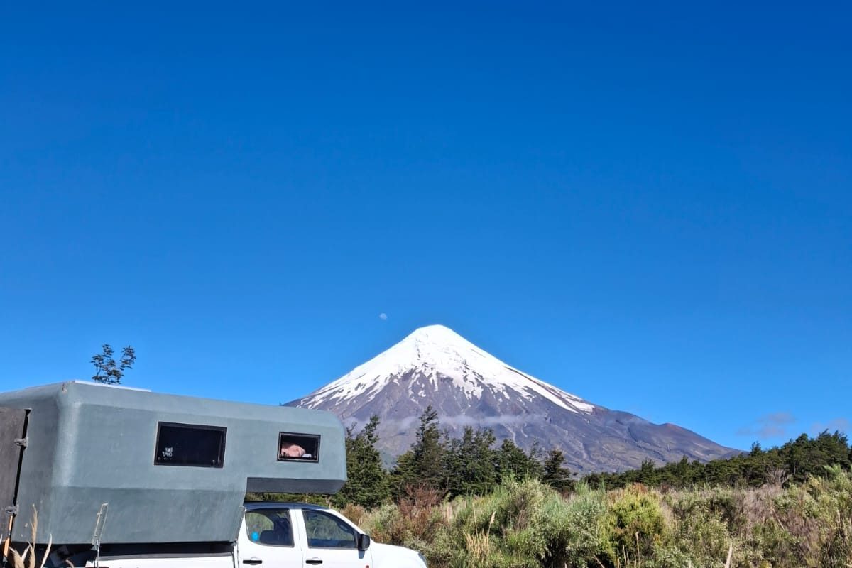 Camper truck 4x4 frente a un volcán nevado